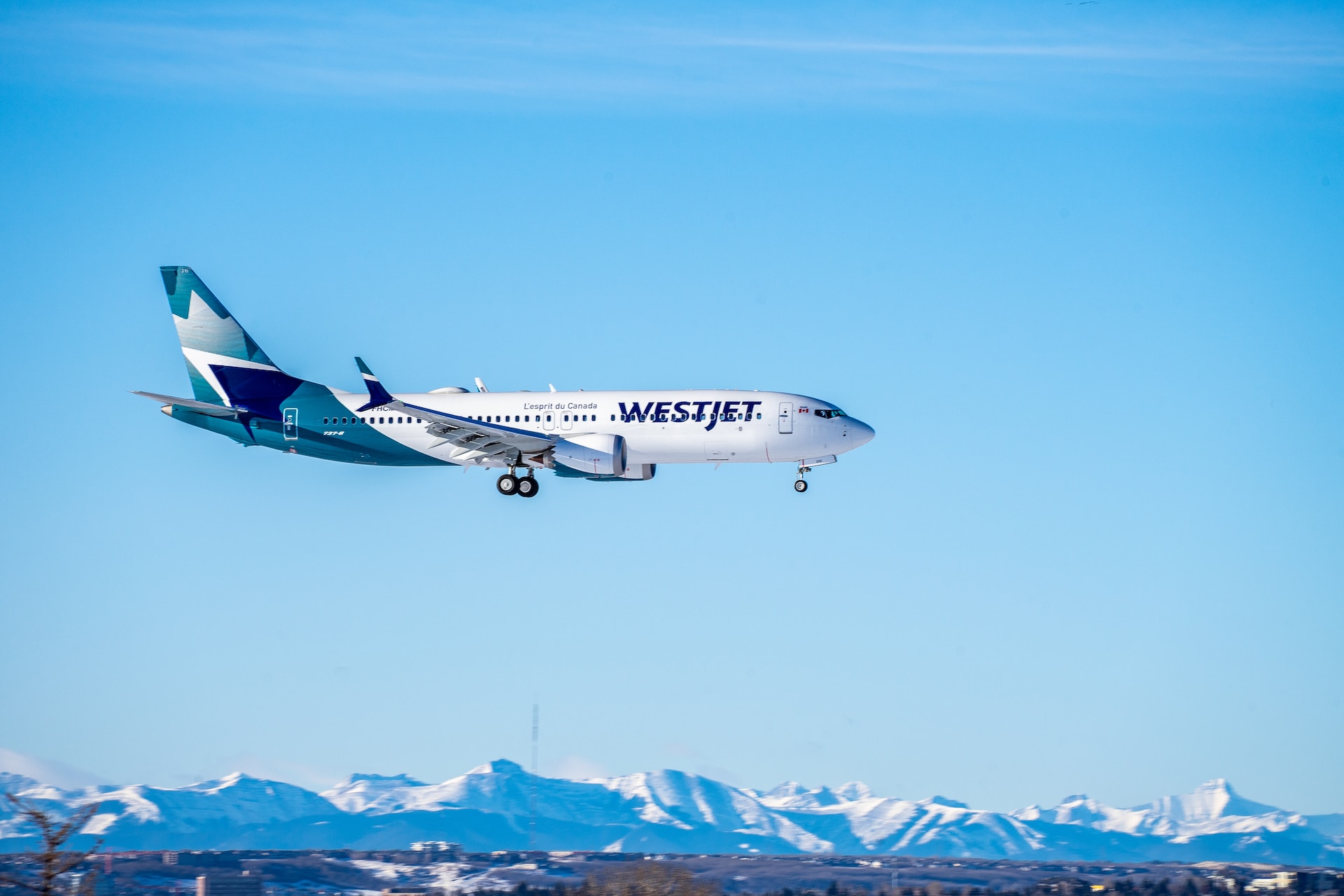 WestJet 737 landing in Canada on a blue sky day.