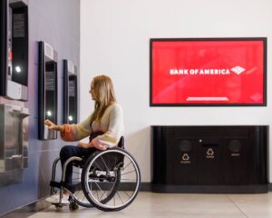 A woman in a wheelchair uses a Bank of America ATM