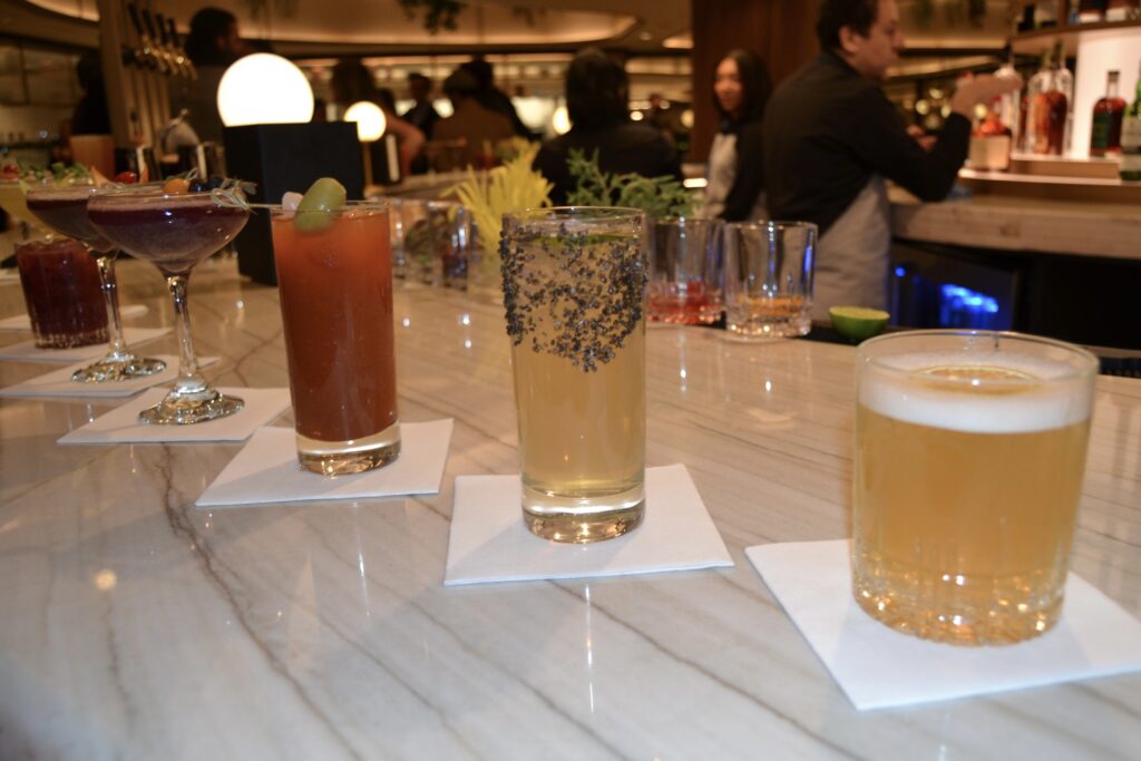 mixed drinks and cocktails sitting on a bar