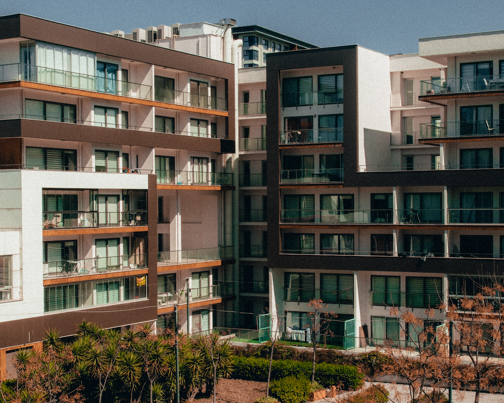 an apartment complex with gardens and a pool in the middle