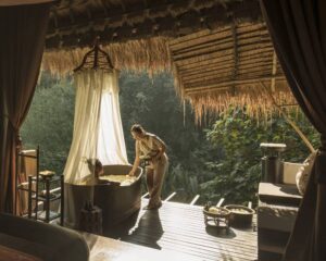 A woman takes a bath overlooking the wilderness at Four Seasons Tented Camp Thailand.