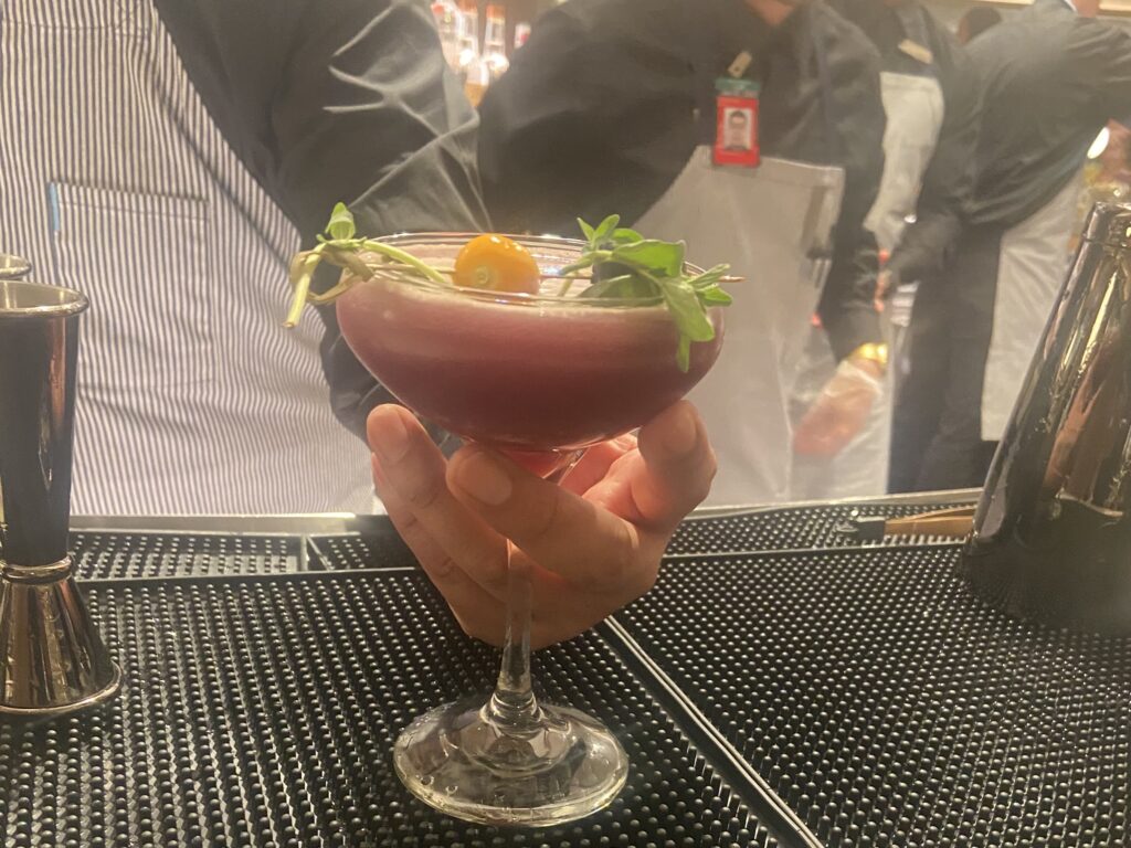 a bartender serves a cocktail in the LGA location of the Sapphire Lounge