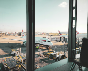 looking out an airport window at British Airways planes on the apron