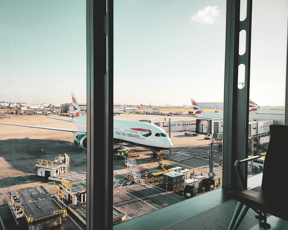 looking out an airport window at British Airways planes on the apron