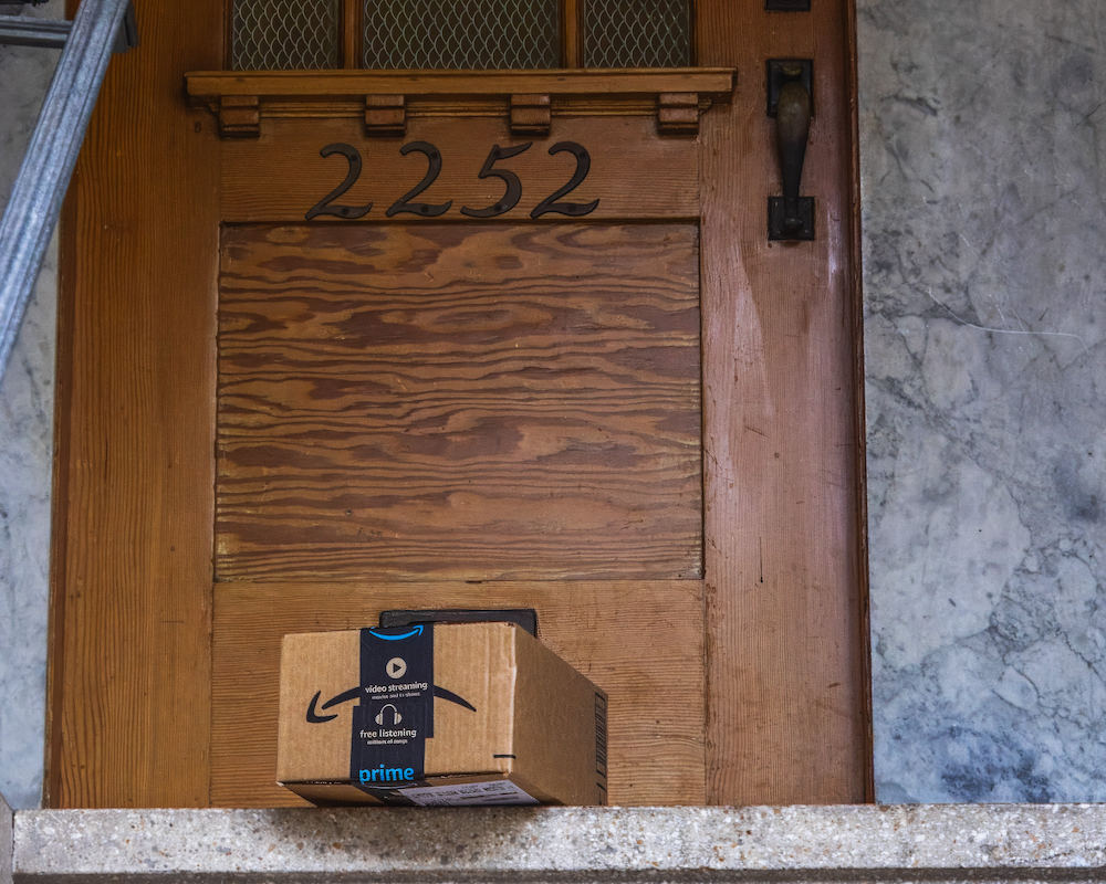 Amazon box on porch in front of a wooden door