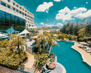 a pool flanked by palm trees and lounge chairs at a luxury hotel