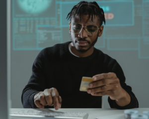 a man holding a credit card while using a computer