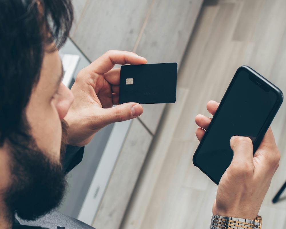 Looking over the shoulder of a man with credit and smart phone