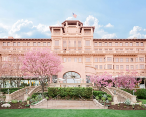 Front entrance of The Langham Huntington in Pasadena, California with cherry blossom trees in bloom