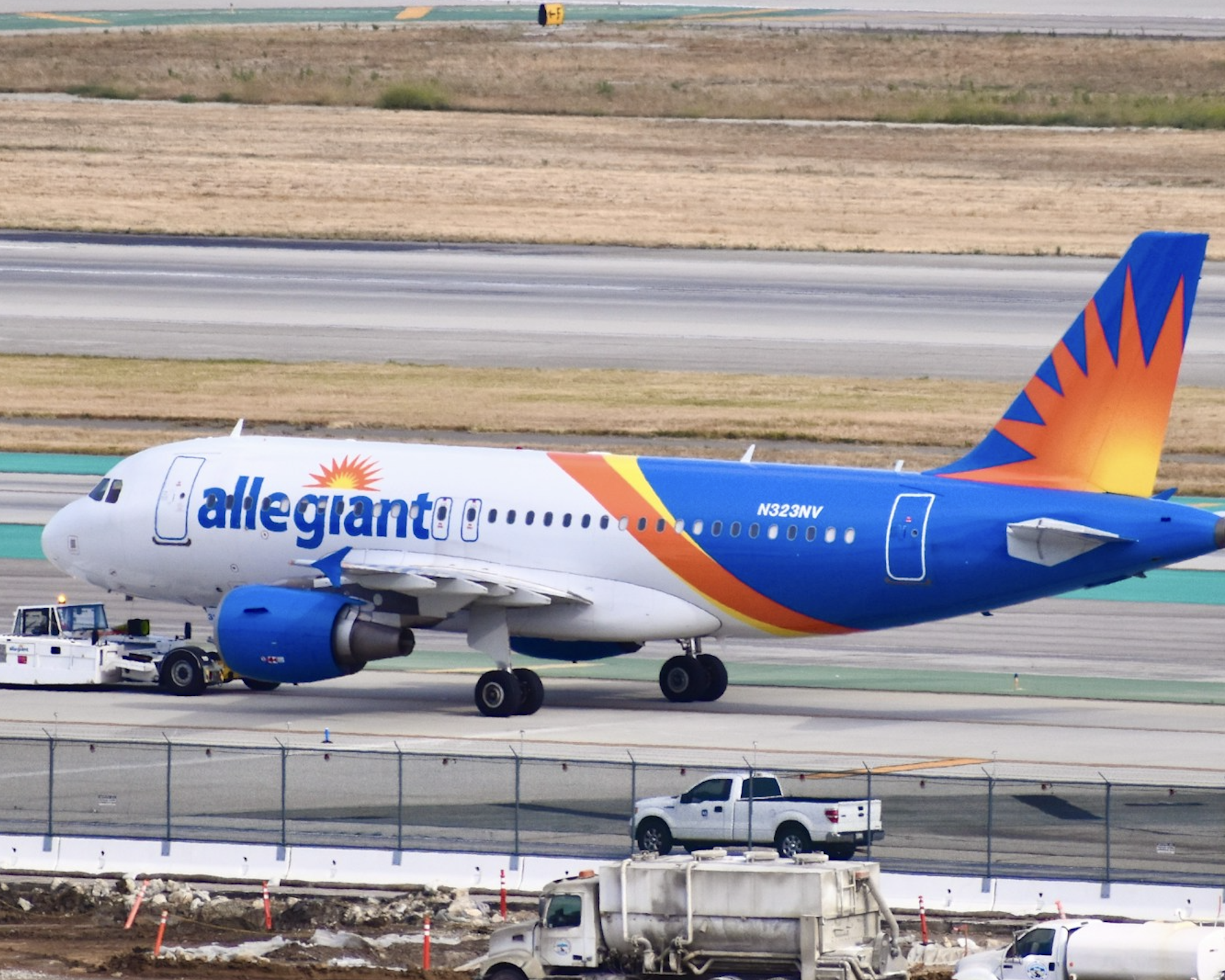 Allegiant A320 getting towed by a tug.