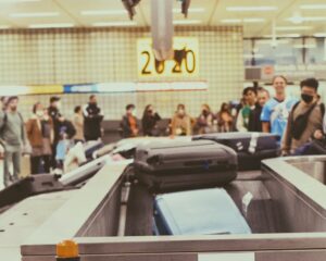 Airport passengers wait for luggage coming out on a baggage claim carousel