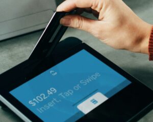 A woman swipes her card to make a payment.