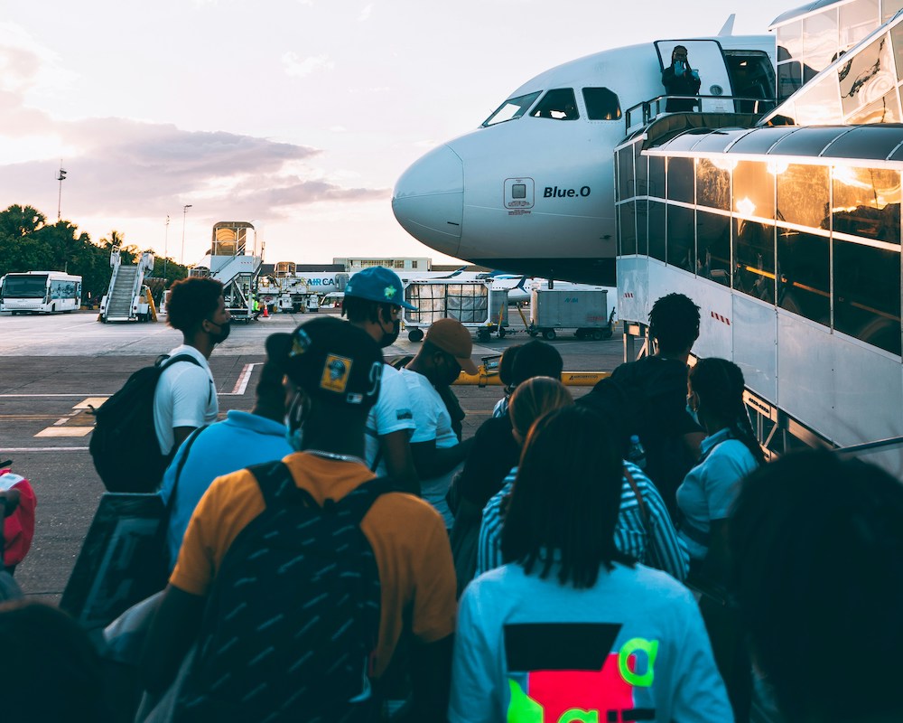Passengers line up near a ramp to board a JetBlue plane