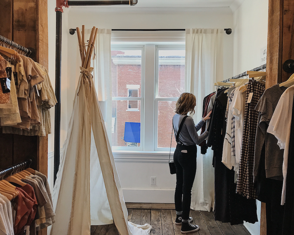 a woman browsing clothes on the rack at a store