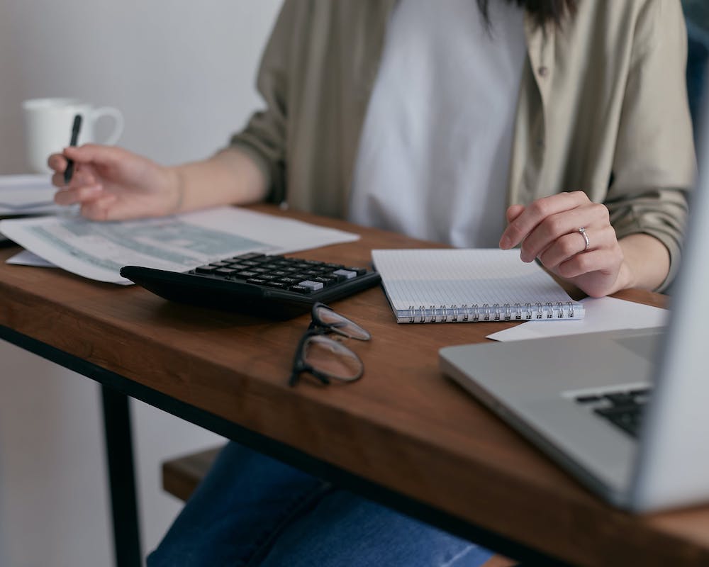 a woman sits at a desk with business documents spread out
