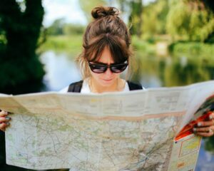 a woman looks at a large unfolded map