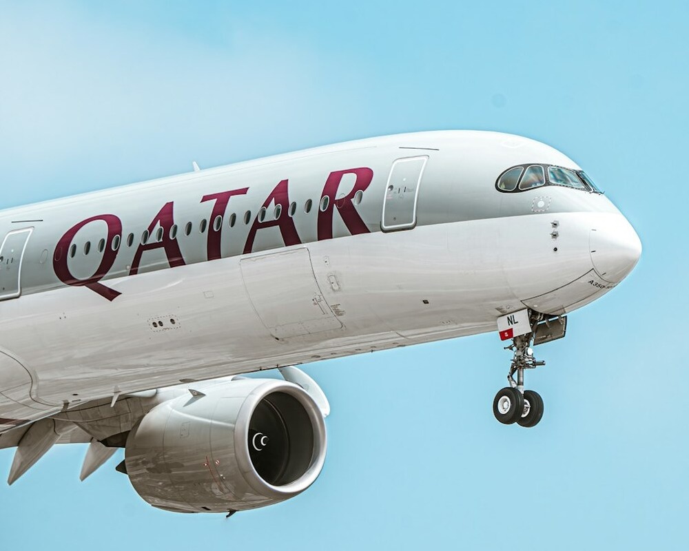 Qatar Airways A350 landing in blue skies.