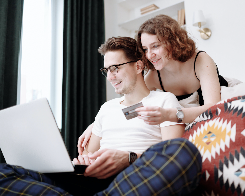 a couple looking at a credit card and a laptop