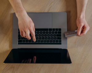 overhead view of hands typing on a laptop and holding a credit card