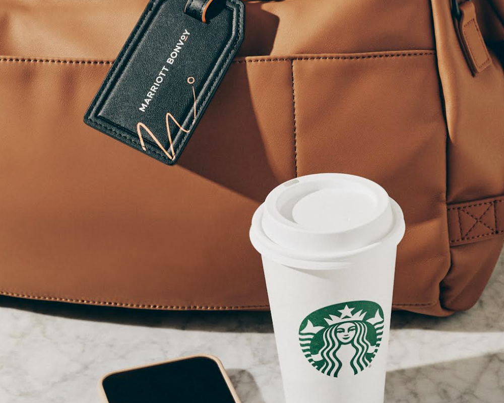 Starbucks coffee cup next to a Marriott-tagged bag.