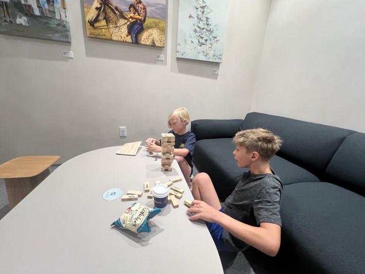 Photo shows two boys playing a Jenga game at a Capital One Cafe