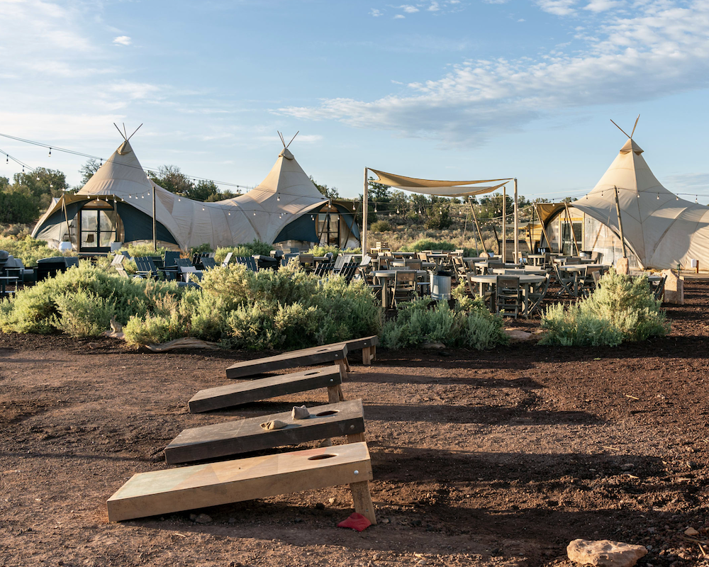 Wide angle photo of the Under Canvas Grand Canyon, including tents and corn hole boards.