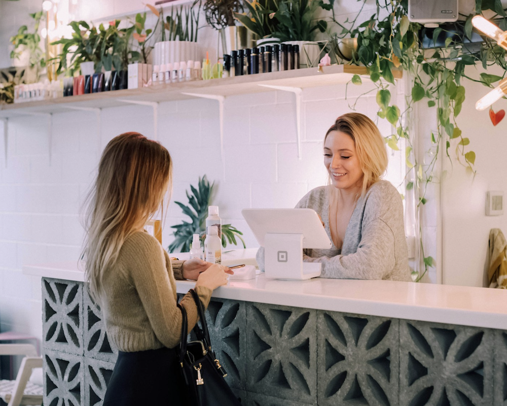 Woman paying digitally at a juice bar counter.