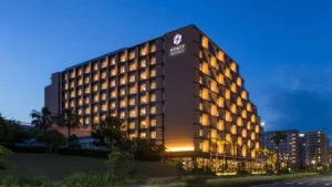 Large hotel at twilight with windows lit and Hyatt Regency written on the darkened building