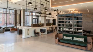Hotel lobby with black lights hanging down, black chairs, and brown shelves