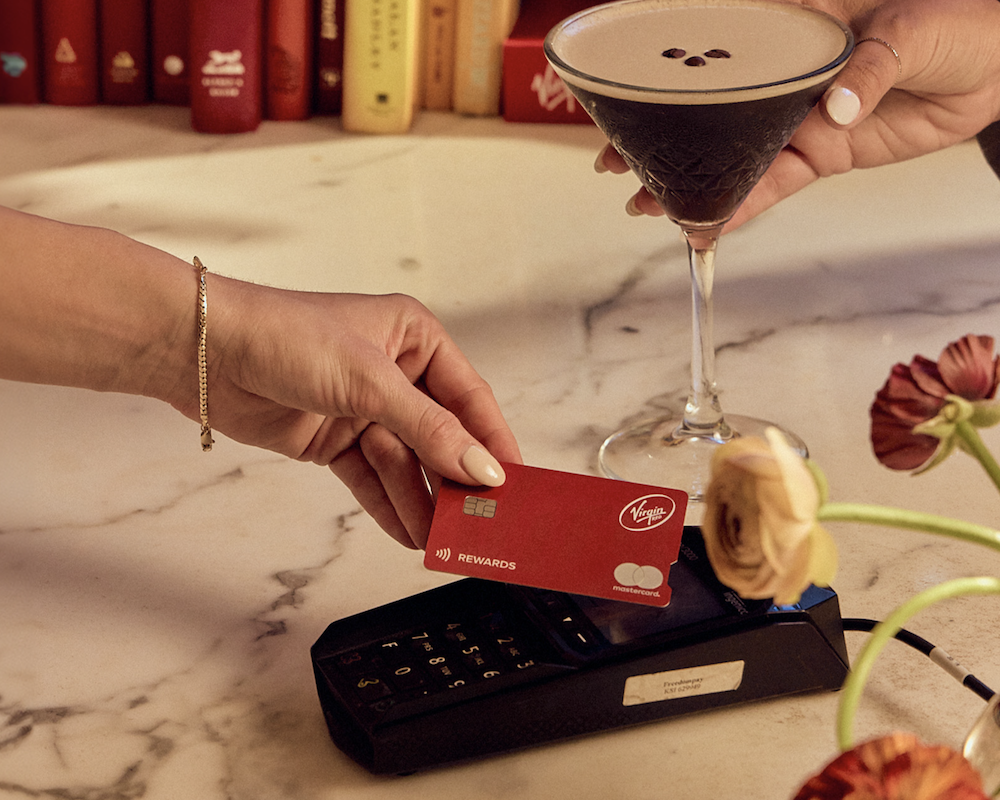 Person tapping the Virgin Red Card on a card reader at a bar.