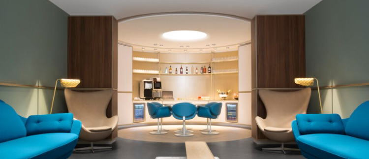 The Air France lounge at CDG Airport in Paris with blue seating and a bar in the background.