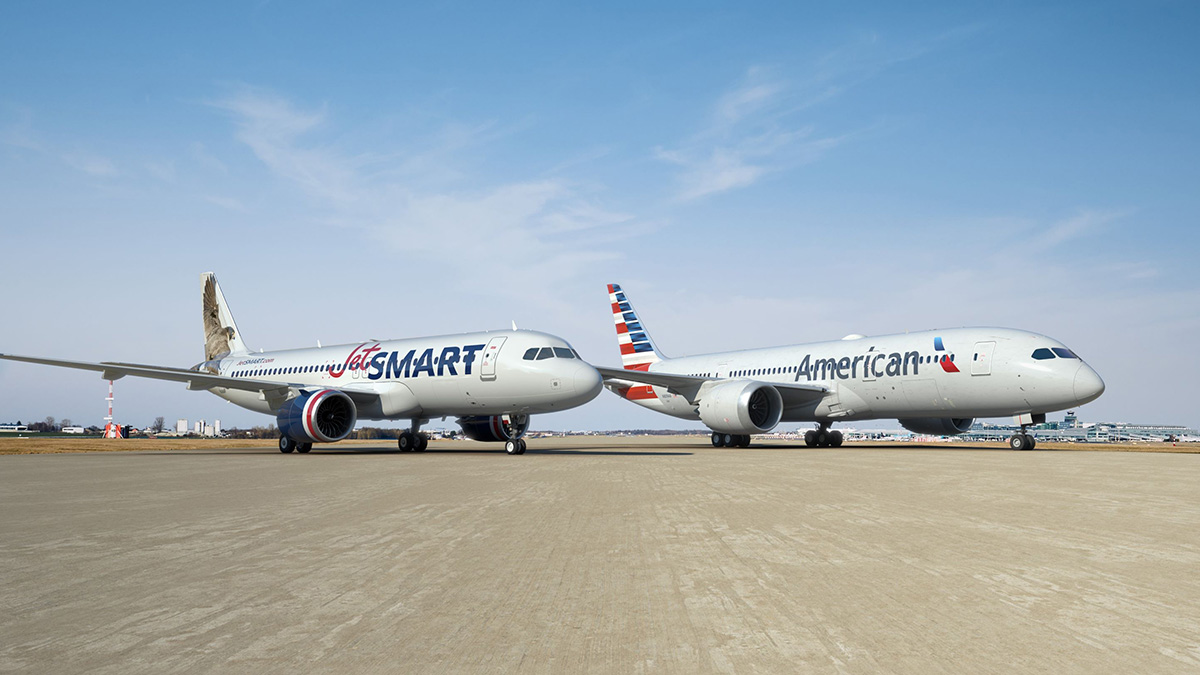 JetSMART plane parked next to an American Airlines plane.