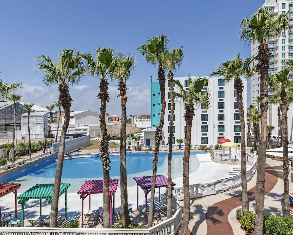 Pool and palm trees outside of the Holiday Inn Resort South Padre Island-Beach Front.