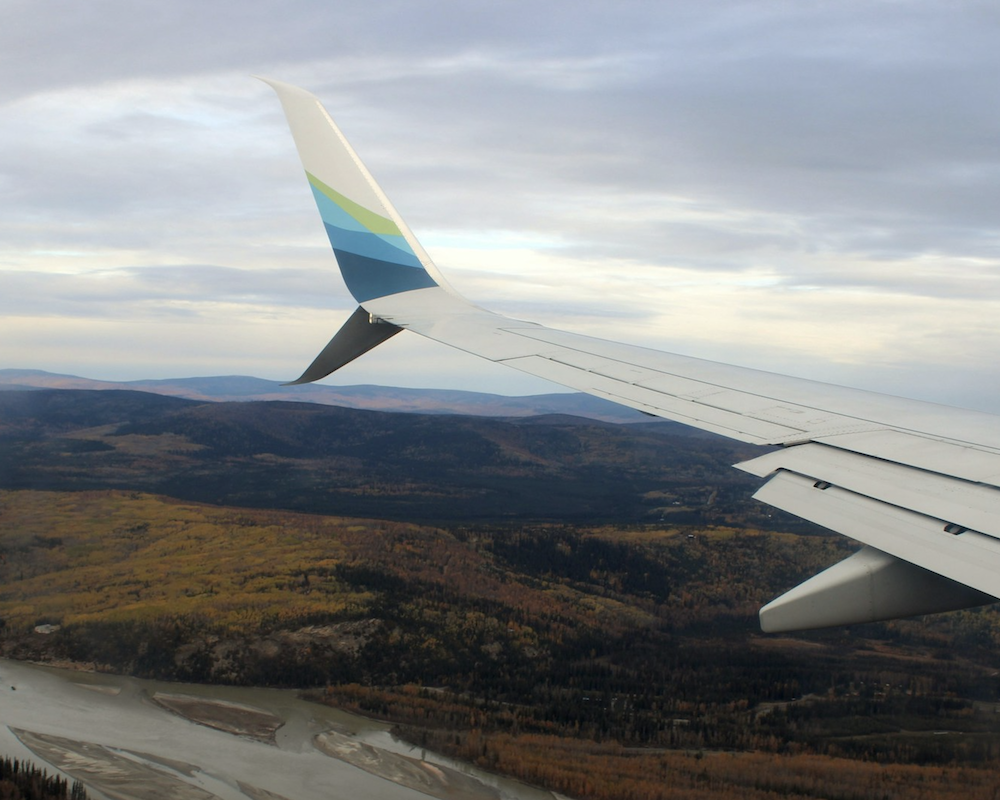 View of the wing of an Alaska Airlines plane as seen from inside the cabin.