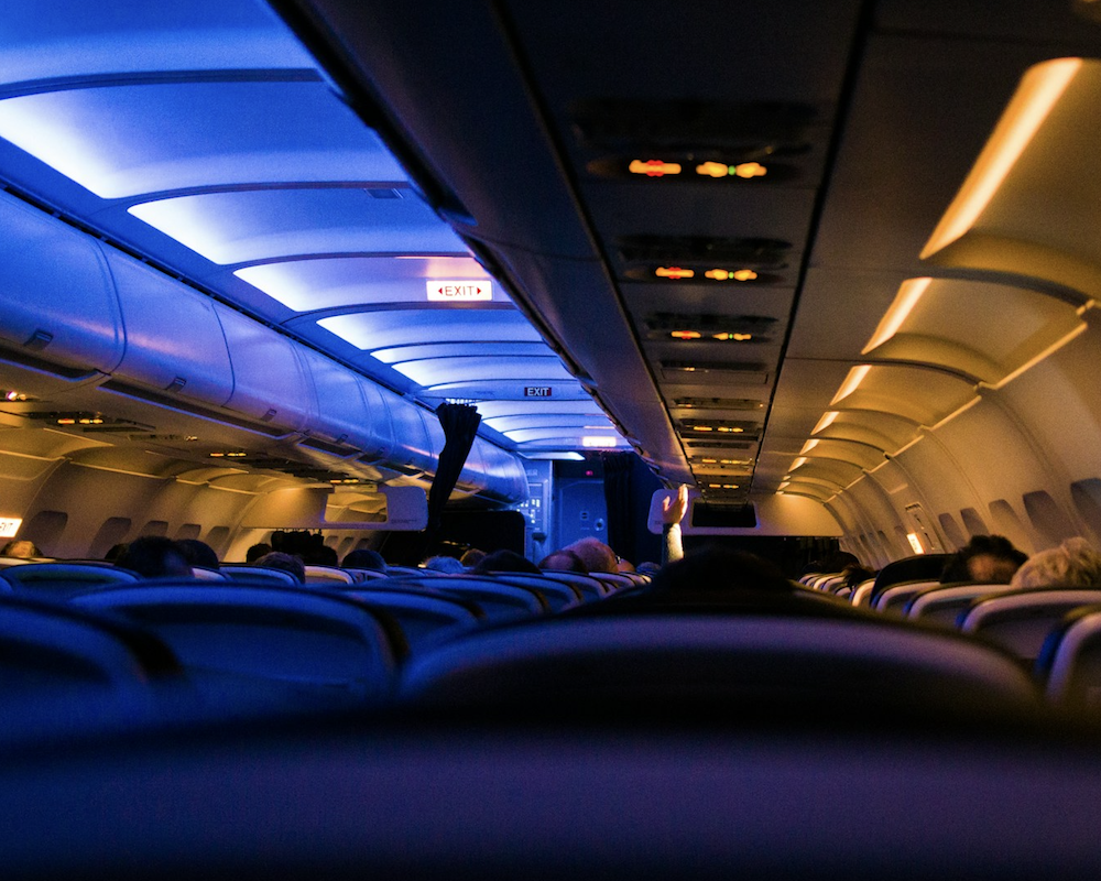 Interior of a dimly-lit British Airways airplane.