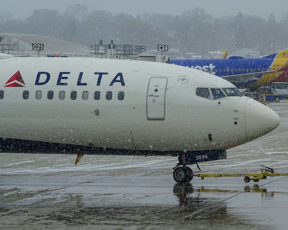 Delta 737 getting pushed back at MKE Airport in the snow.