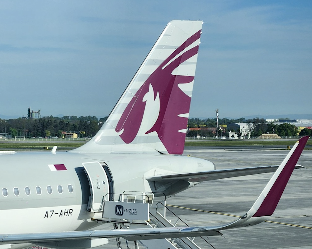 Qatar Airways A320 jet parked at a gate.