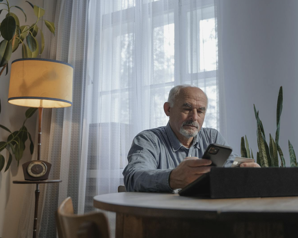 A Low Angle Shot of an Elderly Man Using His Mobile Phone