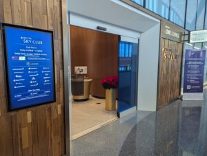 Delta One Lounge and Sky Club entrance in Boston with signage showing operating hours