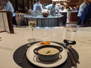 Delta One Lounge Boston clam chowder with grill blurred in the background