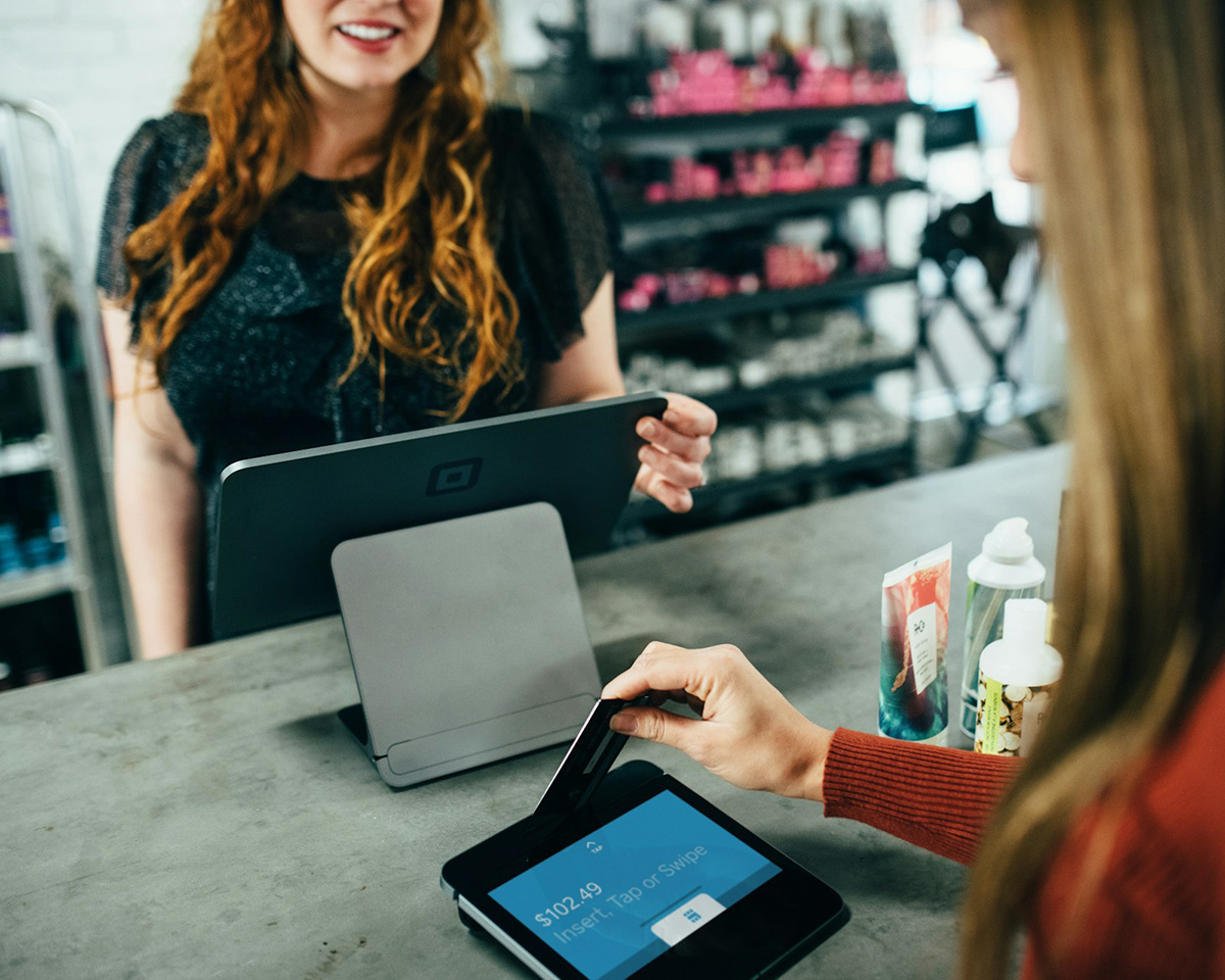 Woman using a credit card at a point of sale terminal