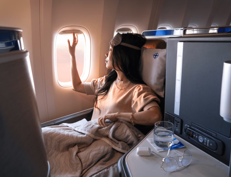 A photo of a woman sitting in business class on a United Flight.
