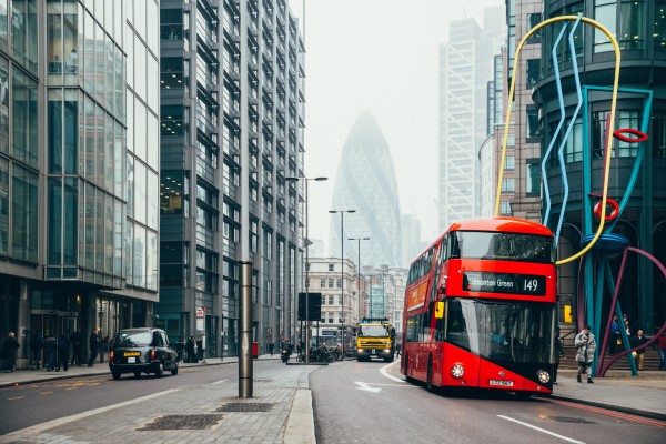 A photo of a city street in London with a double decker bus.