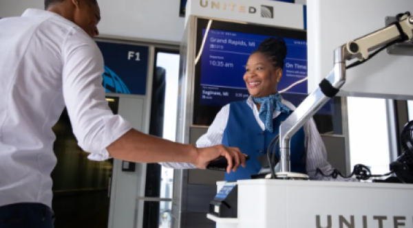 A United gate agent checks boarding passes in this photo