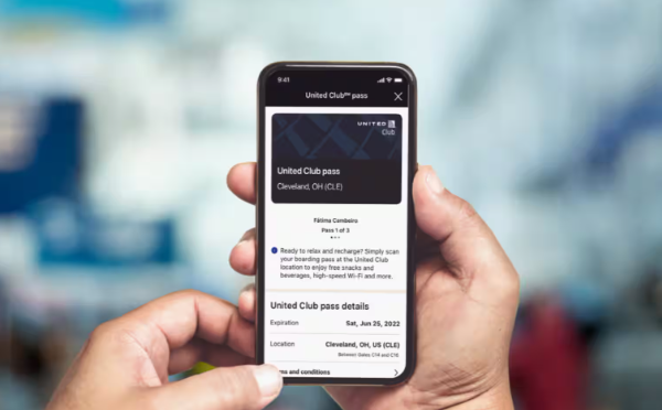 A photo of hands holding a phone that shows a United One-time pass