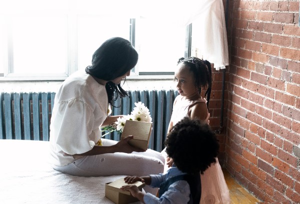 Two children give a gift to their mother.