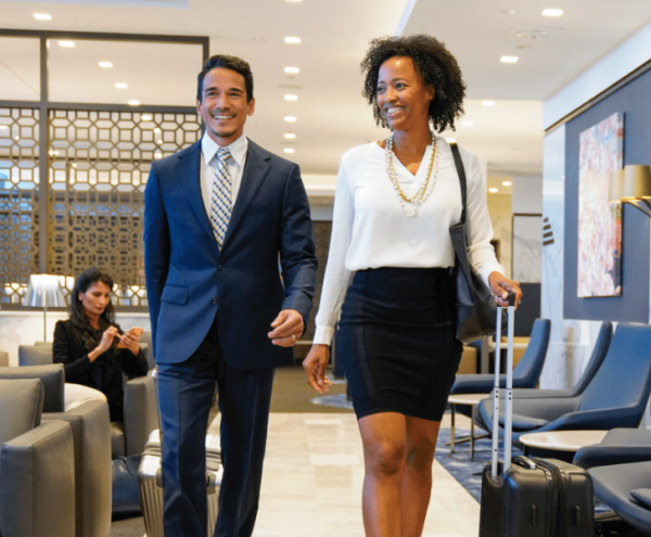 A photo of a man and woman walking through a United Club