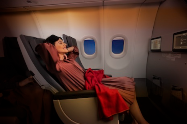 A photo shows a woman stretched out in extra legroom seats on a TAP flight.