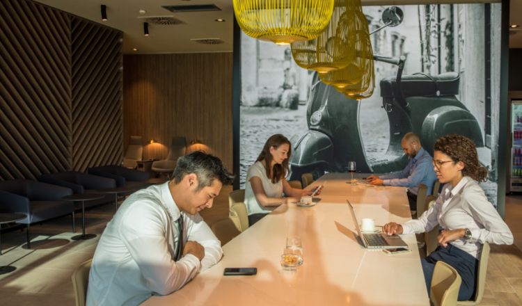 A photo shows people working in an airport lounge