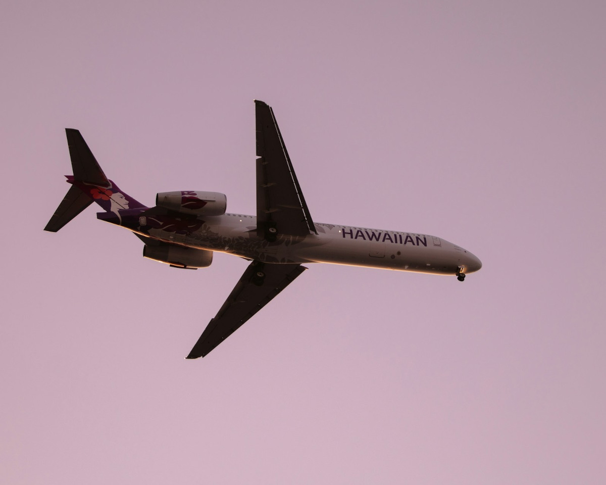 Hawaiian Airlines aircraft flying against a red sky